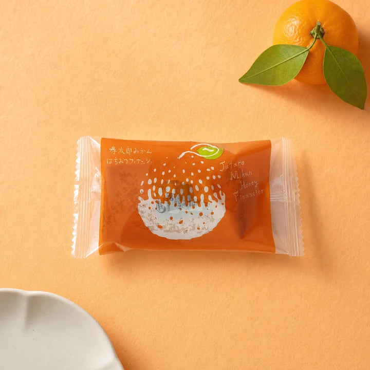 Mikan Honey Financier with Shizuoka mandarins on a warm orange background