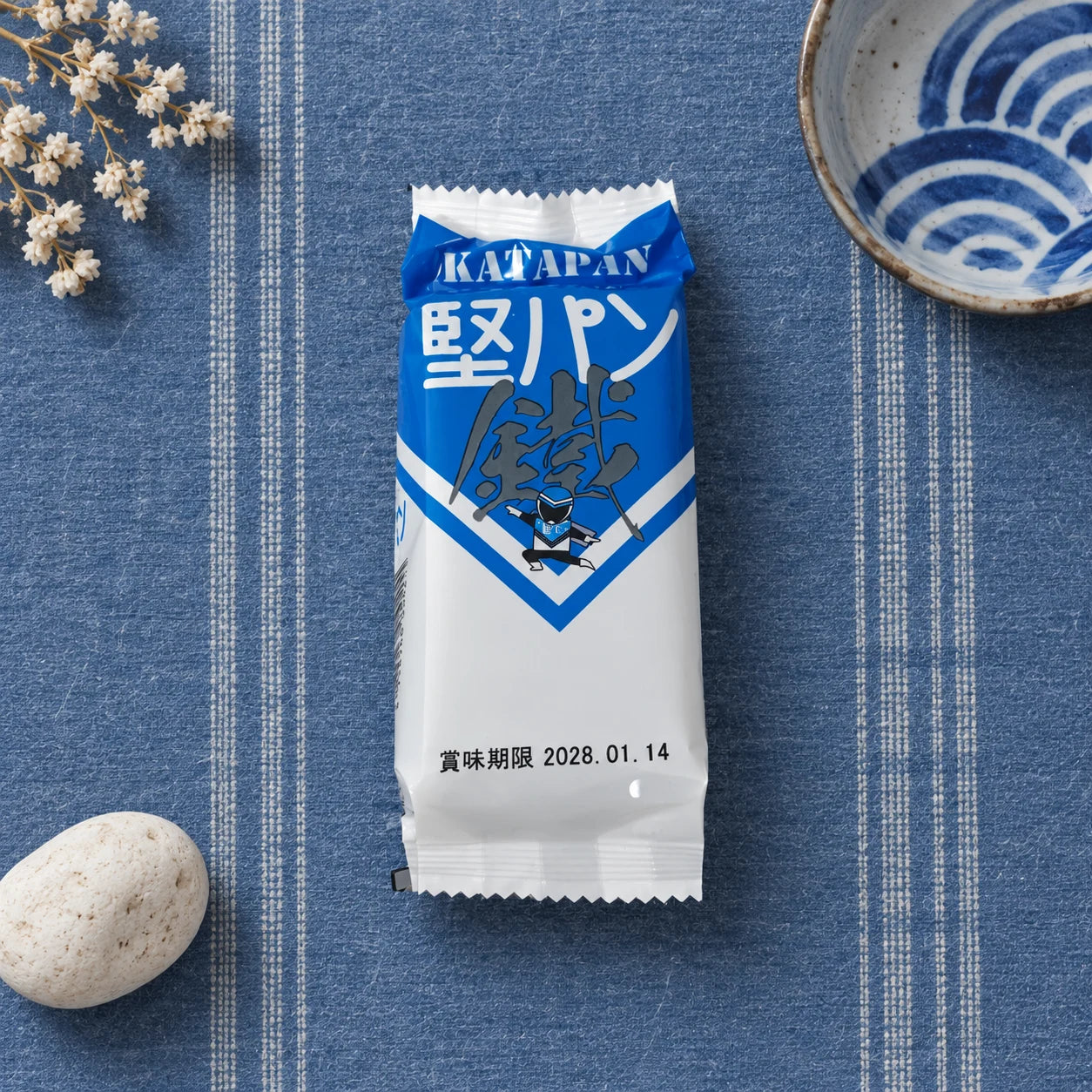 Kurogane Katapan Stick on a blue Hakata textile-inspired background